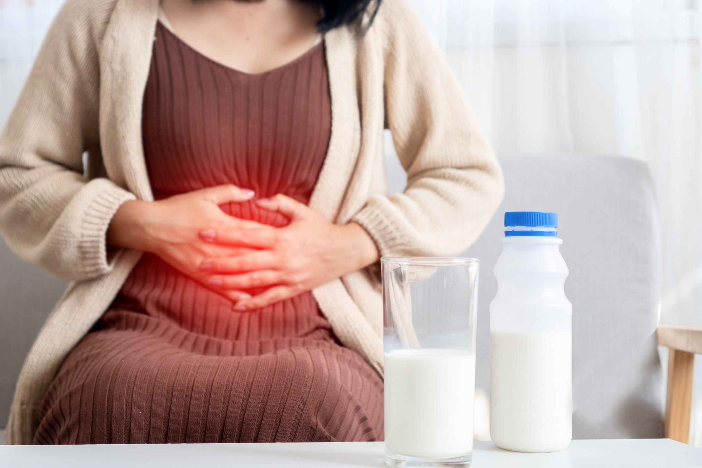 woman holding stomach , Indigestion and stomachache after drinking  cow Milk